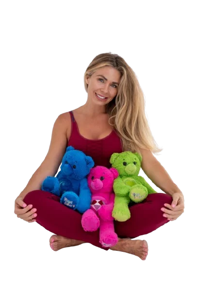 Estelle McCluskie, founder of YogaBears, sitting cross-legged with three YogaBears plush characters