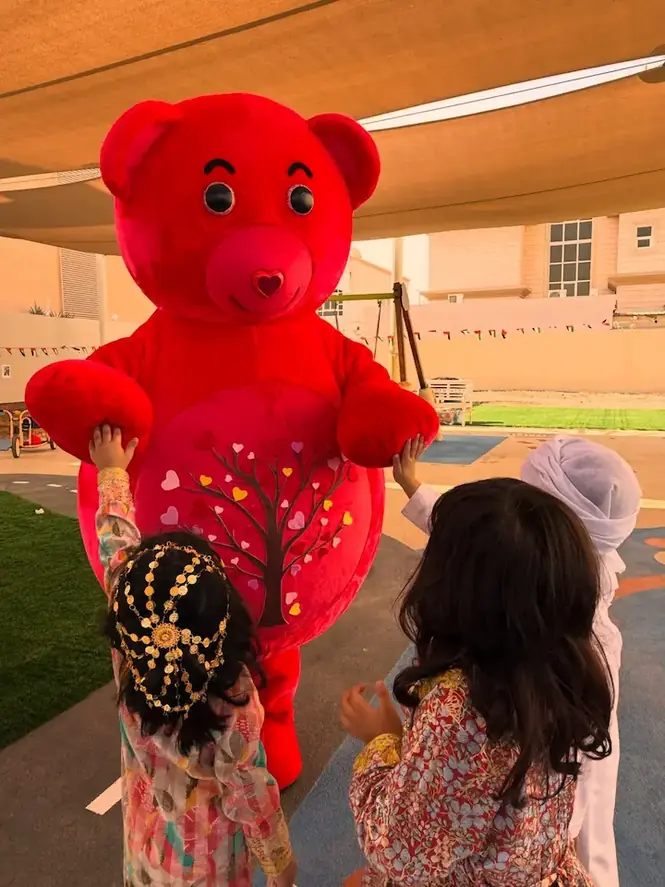 Children at a nursery playing outdoors with a life-size YogaBears character
